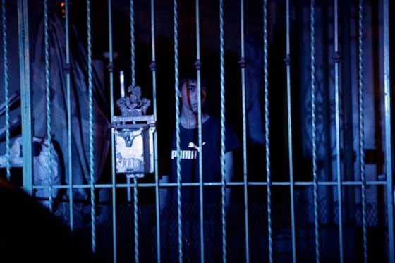 A youth watches a crime scene from behind his home's fence after a man was murdered in Ciudad Juarez, Mexico, on April 16. According to police at the scene, the murder appeared to be related to organized crime.